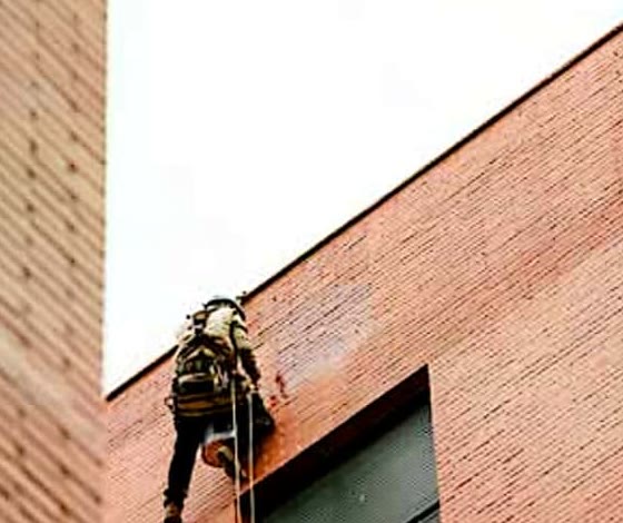 Alpinista industrial trabalhando em fachada